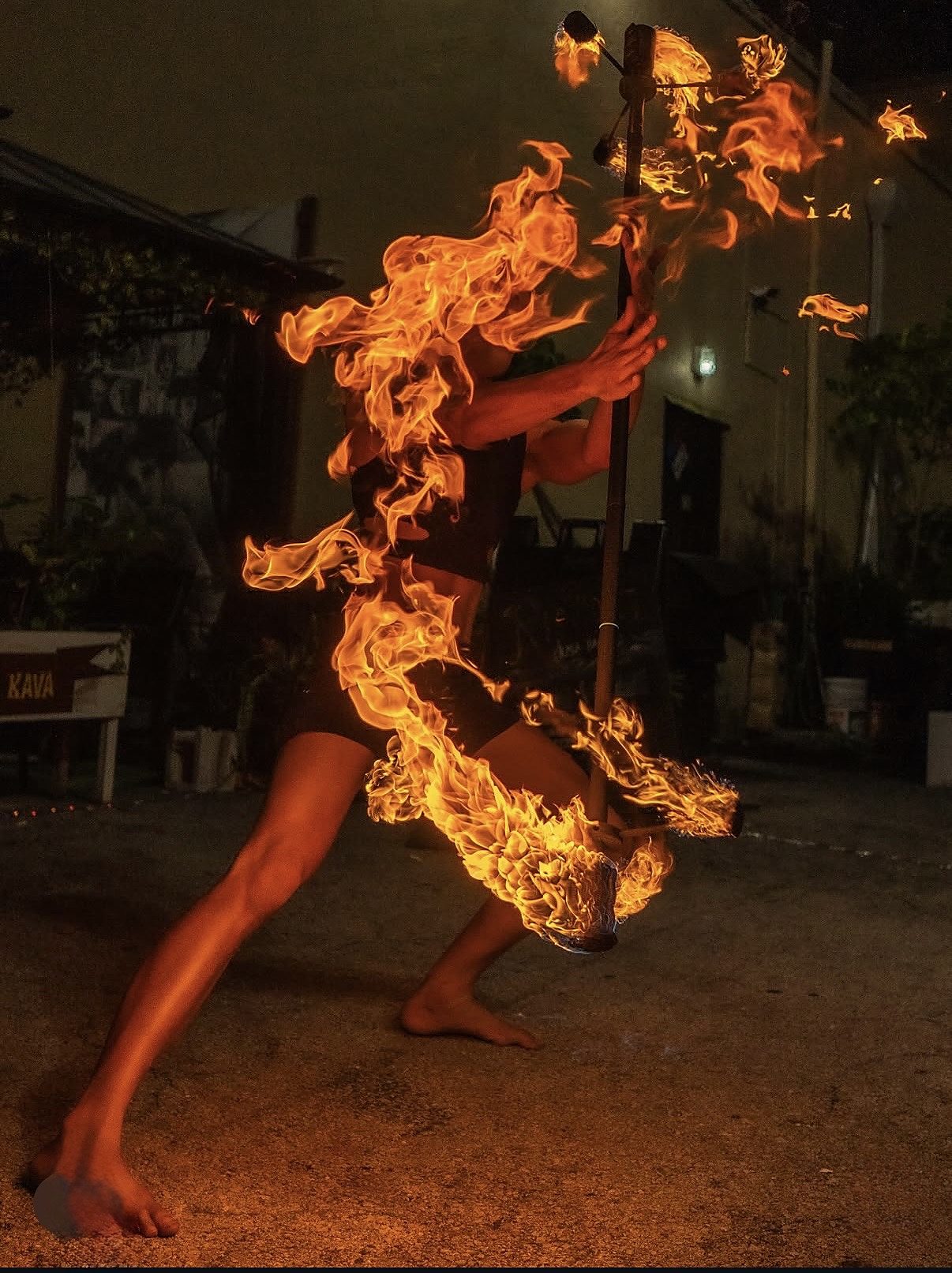 Jake mid-spin with a fire staff, the flame wrapping around his body in a long arc